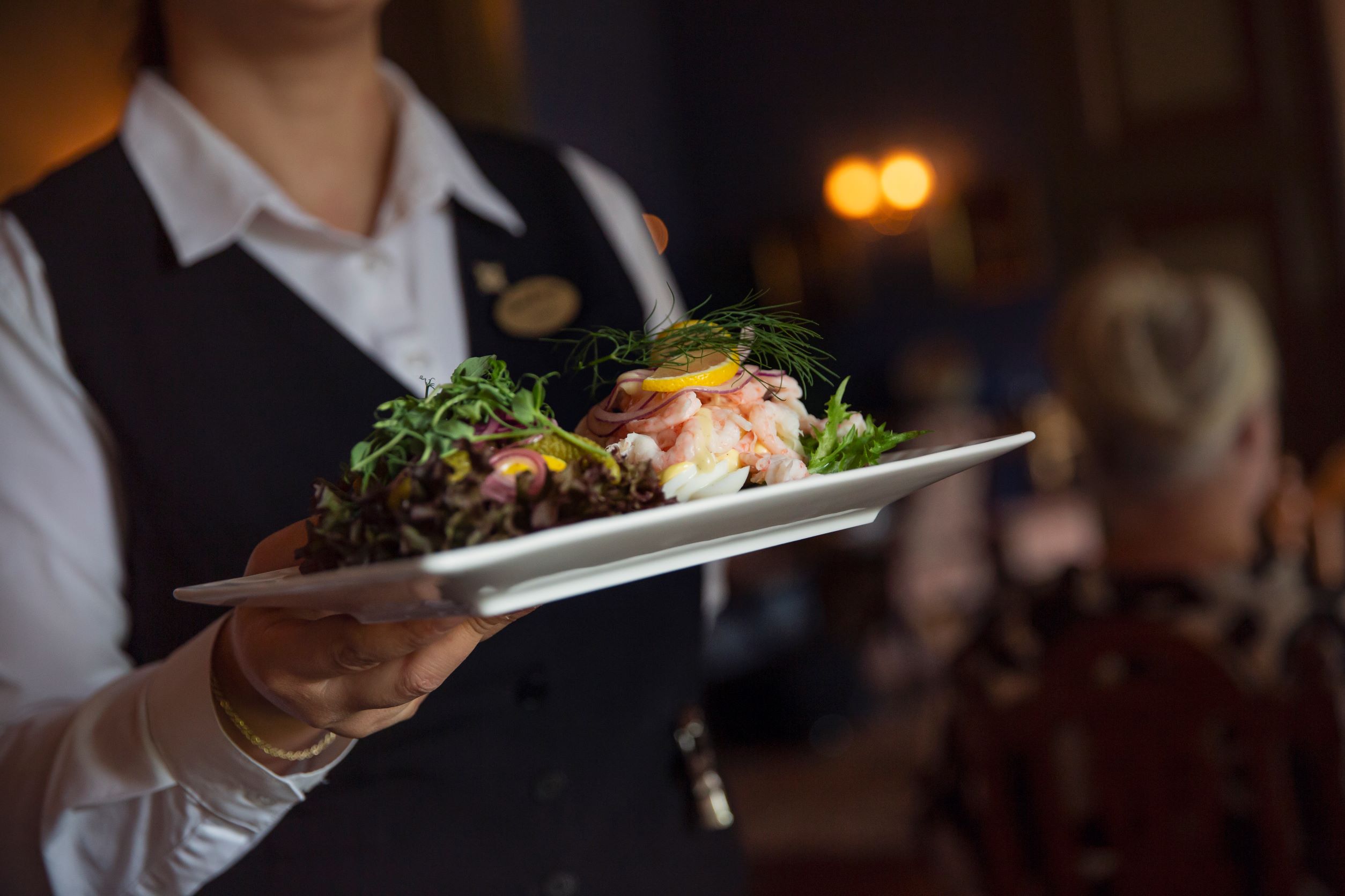 Waiter serving a shrimp sandwhich